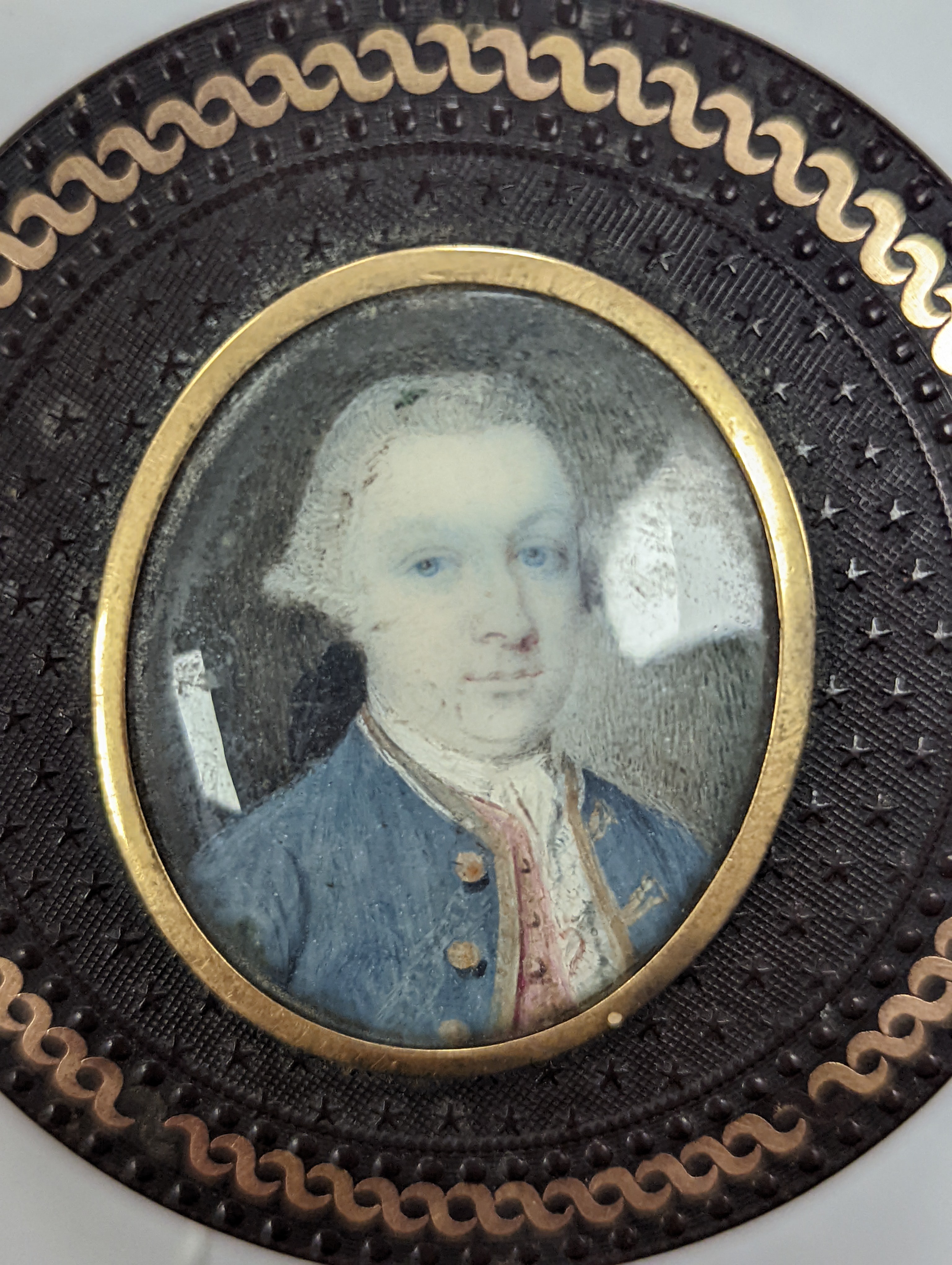 A 19th century pressed bois durci and gilt metal snuff box with painted miniature portrait of a gentleman on ivory to cover. 6cm diameter